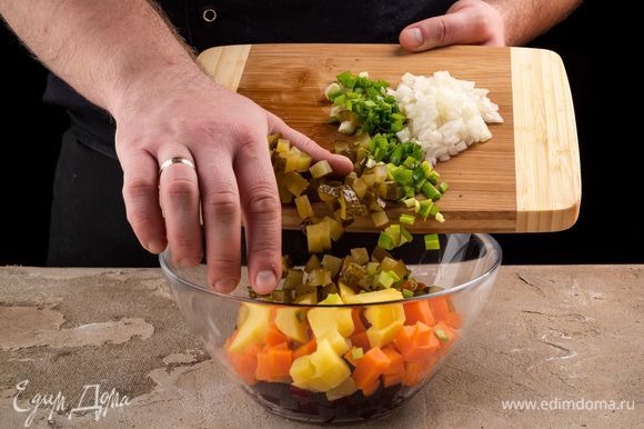 Нарежьте кубиками огурцы. Соедините овощи. Добавьте измельченный лук, специи по вкусу.