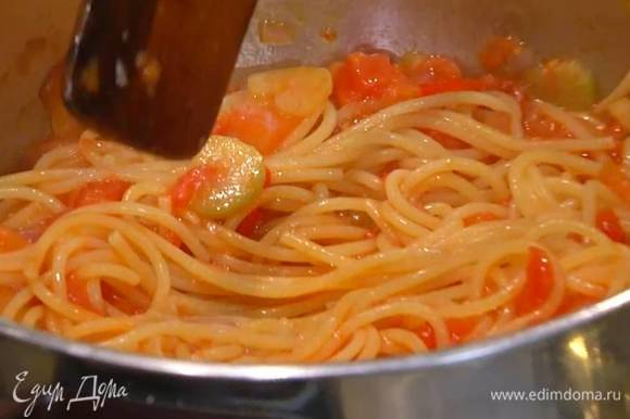 В кастрюлю с макаронами добавить овощной соус, влить немного воды, в которой варились спагетти, поместить кастрюлю на огонь и все немного прогреть.
