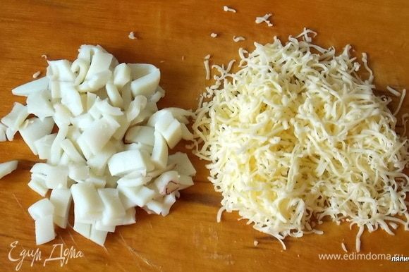 Сыр нужно натереть на мелкой терке, вареные кальмары порезать.
