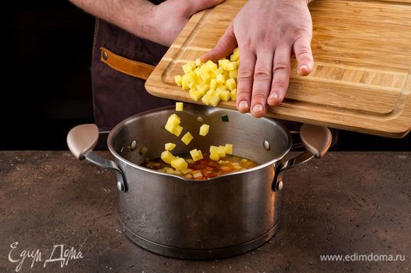 Добавьте нарезанный кубиками картофель, посолите и варите на медленном огне до готовности картофеля.