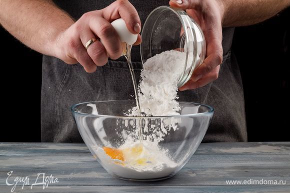 Приготовьте песочное тесто. Для этого смешайте мягкое сливочное масло со 100 г сахарной пудры и яйцом.