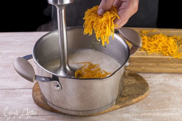 Пюрируйте суп блендером, добавьте 150 г тертого сыра и полностью растворите.