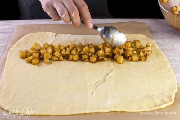 На пергаменте раскатайте тесто и выложите начинку.