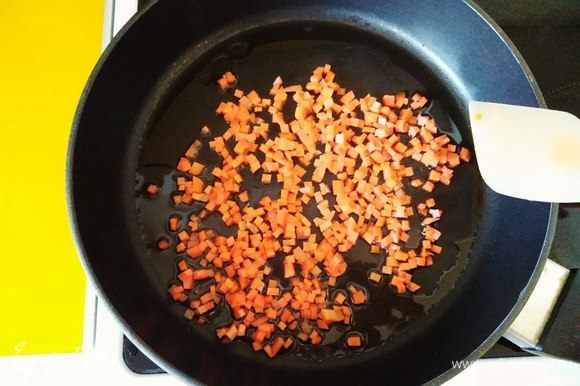 Ставим сковороду на средний огонь, наливаем оливковое масло. После того как масло прогрелось, бросаем морковь и обжариваем в течении 1–2 минут.
