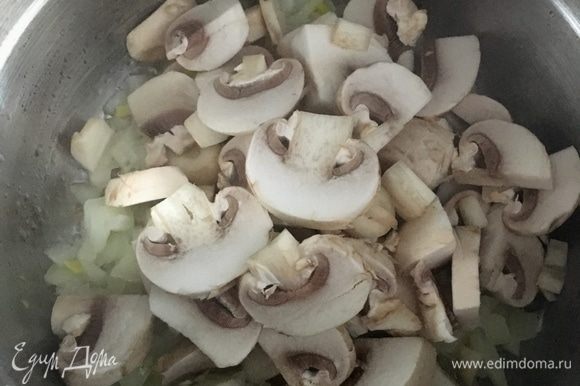 Когда лук станет прозрачным, добавить к нему нарезанные грибы. Посолить и поперчить немного.