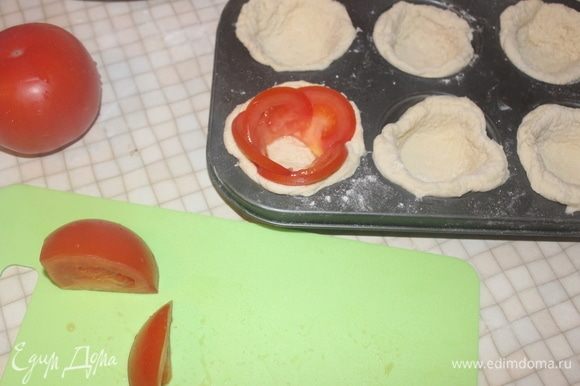 Нарезаем помидор полукольцами и выкладываем по бокам теста.