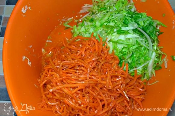 К нашинкованной капусте добавляем морковь по-корейски прямо с соком, желательно сразу перемешать ингредиенты, чтобы капуста стала более ароматной.