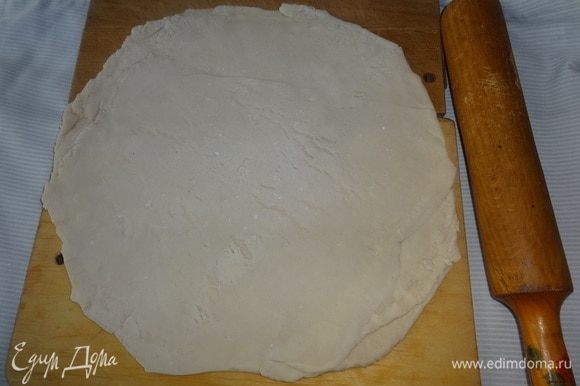 Раскатать тесто на подпыленной мукой поверхности, по размеру больше диаметра формы на 3–4 см.