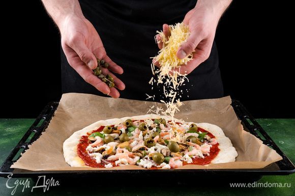 Сверху посыпьте пиццу тертым пармезаном, добавьте каперсы и оливки.