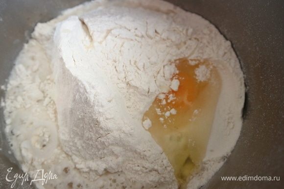 Добавить яйцо, соль, воду, оливковое масло. Перемешать миксером с насадками-крюками сначала недолго на минимальной скорости, затем скорость увеличить, перемешать.