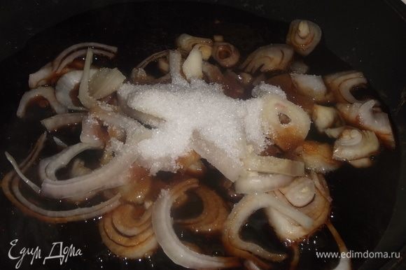 В сковороду налить соевый соус. Довести до кипения и добавить нарезанный полукольцами лук. Посыпать сахаром. Обжаривать, помешивая, 3 минуты.