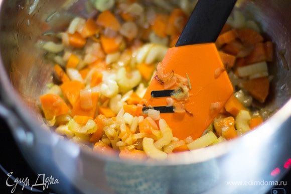 Лук, морковь и сельдерей нарезать мелкими кубиками, чеснок измельчить. В большой кастрюле разогреть масло, сложить в нее лук, морковь, сельдерей, чеснок и розмарин, готовить на среднем огне 5 минут, помешивая.