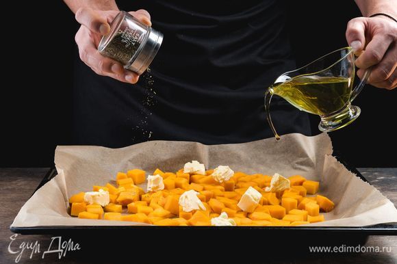 Застелите противень бумагой для выпечки, выложите тыкву, посолите, поперчите, посыпьте орегано, сбрызните оливковым маслом и положите кусочки сливочного масла. Запекайте тыкву 15 минут при 200°С.