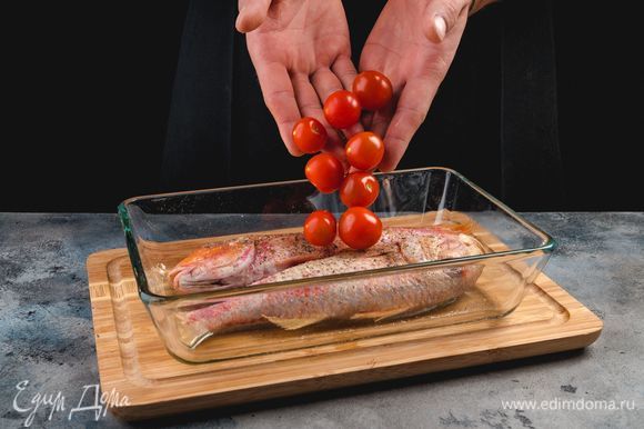 Смажьте форму для запекания оливковым маслом и выложите в нее рыбу, помидоры черри и специи по вкусу.