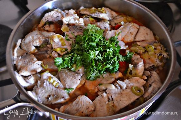 На тушеные овощи аккуратно выложите рыбное филе с луком и чесноком, добавьте рубленную петрушку, накройте крышкой и тушите еще 3–5 мин.
