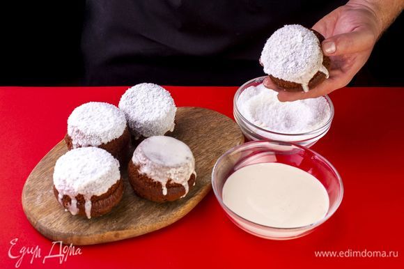 Смажьте кексы глазурью и, пока она не застыла, окуните каждый кекс в кокосовую стружку. Украсьте кексы.