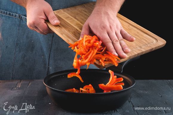 Обжарьте нарезанный перец на сковороде.