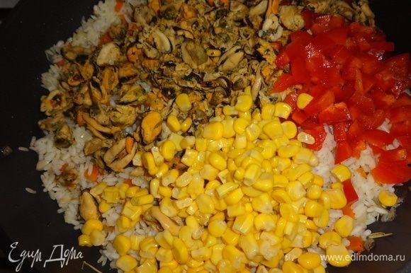 В сковороду с рисом и овощами добавить отваренное мясо мидий, консервированную кукурузу и сладкий красный перец, перемешать. Потушить под крышкой 5 минут и выключить огонь. Дать паэлье настояться 5–10 минут.