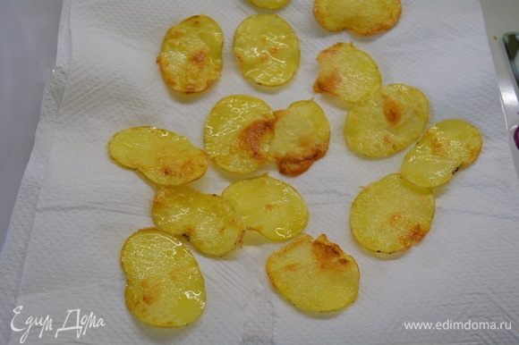 Выложить чипсы из картофеля на салфетку, чтобы впиталось лишнее масло. Посолить.