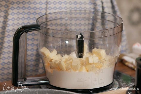 Приготовить тесто: 150 г предварительно охлажденного сливочного масла нарезать небольшими кубиками и вместе с мукой измельчить в блендере в крошку, затем посолить и еще немного взбить. Добавить желток и, продолжая взбивать, влить по одной 4 десертные ложки ледяной воды.