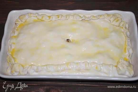 Начинку закроем «крышкой» из теста, защипнем края и смажем пирог яичным желтком, сделаем отверстие по середине. Выпекать при 180°C примерно 40 минут.