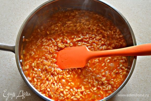 Затем влейте рыбный бульон, половину томатного соуса и готовьте на среднем огне, периодически помешивая, 15 минут. По мере выпаривания жидкости добавляйте оставшийся томатный соус.