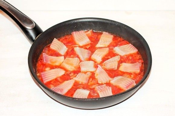 Выложить кусочки рыбы в соус, посыпать приправой, накрыть сковороду крышкой и готовить рагу на медленном огне минут 20. Добавить в рагу рубленую кинзу (по вкусу) и перемешать.