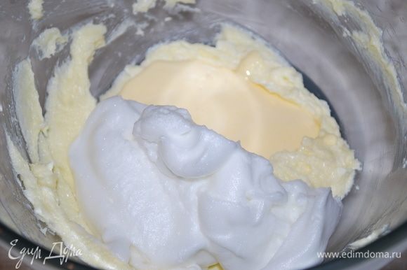 В миску добавляем половину взбитого масла с сахаром, половину яичных белков с сахаром и половину яичных желтков с сахаром. Смешиваем лопаткой снизу вверх. И так в два приема добавляем все три массы, перемешиваем лопаткой аккуратно снизу вверх.