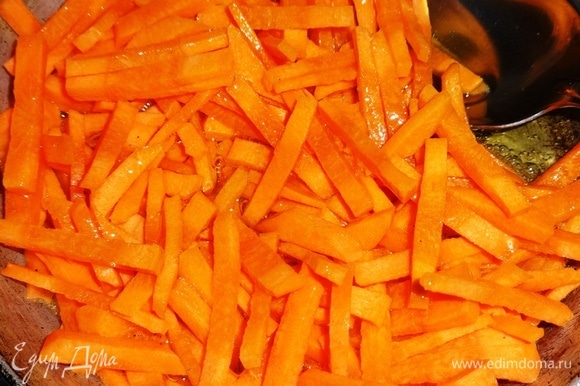 В сковороду налить растительное масло, разогреть его. Положить морковь и обжарить 1 минуту.