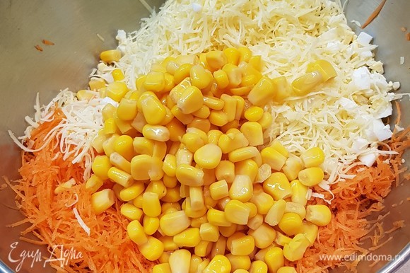К моркови, сыру и яйцам добавить консервированную кукурузу.