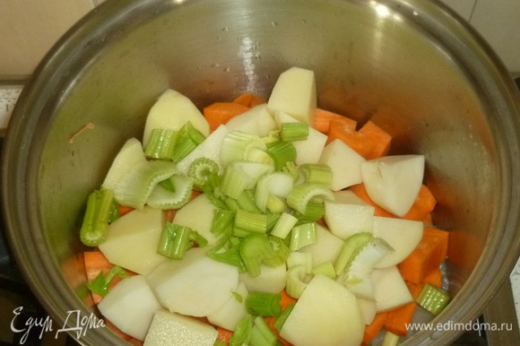 Картофель, морковь и сельдерей нарезать средними кусочками. Выложить в кастрюлю.