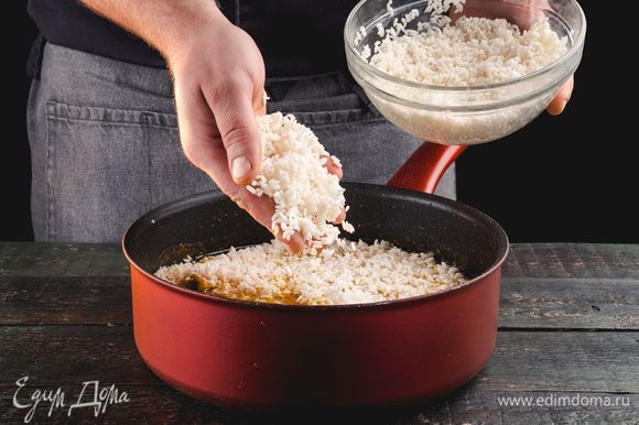 Добавьте рис. Варите 1,5 часа, не перемешивая, но периодически проводя лопаткой по стенкам сковороды, чтобы рис не пригорал.