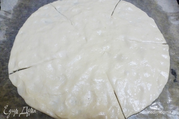 Бумагу для выпечки смазать растительным маслом. Растянуть тесто, формируя круг. Сделать пять надрезов, но не до конца (середина должна быть целой).