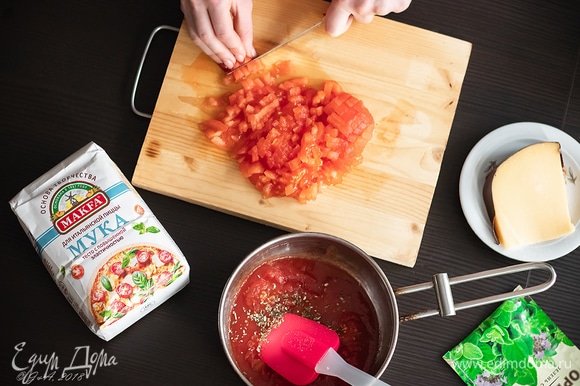 Начинка: самое главное — смазать раскатанное в тончащий пласт теста томатом (соусом) из помидоров и очень обильно. Никакой томатной пасты, никакого кетчупа — ни в коем случае. Для приготовления томата нам потребуется 250 г консервированных в собственном соку помидоров, с которых нужно снять кожицу и размять вилкой. Томаты вместе с соком вылить в сотейник. Туда же нарезать мелким кубиком 180 г свежих бланшированных помидоров. Сотейник поставить на средний огонь и довести до кипения. Туда положить две чайные ложки сахара (помидоры его очень любят). Попробуйте, если нужно, досолите. Также добавьте 0,5 ч. л. сушеного орегано и черного перца и еще немного поварите.