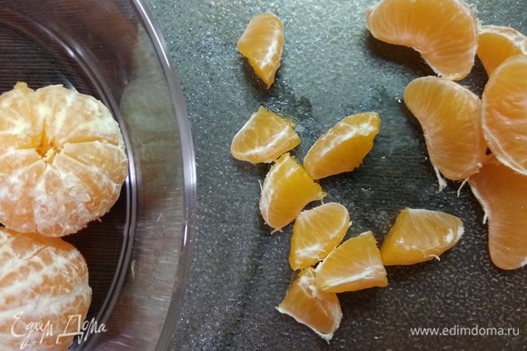 Для начинки чистим мандарины и разрезаем дольки пополам.