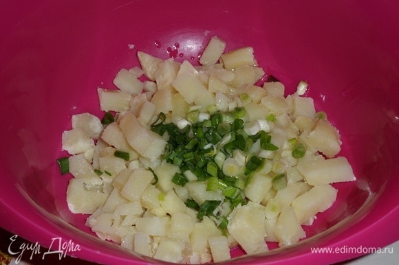 Выкладываем картофель и зеленый лук в чашку. Добавляем чесночное масло.