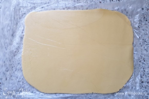 Достаньте тесто из холодильника и раскатайте в прямоугольный пласт толщиной 0,5 см.