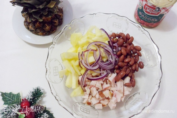Нарезанную кусочками отварную грудку, ананас, красный лук и фасоль выложить в салатник.