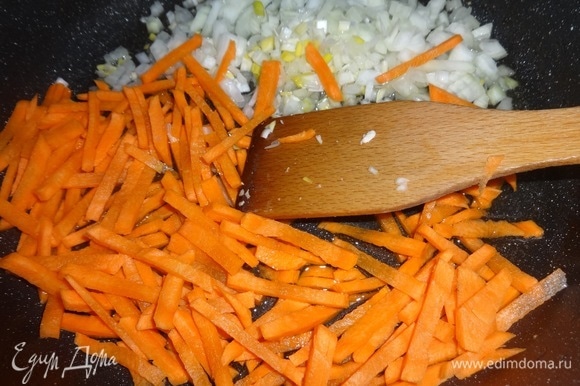 Выложить лук и морковь в сковороду с маслом от курицы и обжарить, помешивая, в течение нескольких минут.