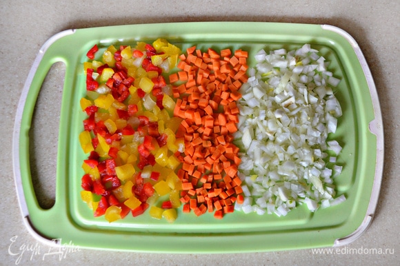 Перец, лук и морковь нарежьте небольшими кубиками. Затем пассеруйте около 3 минут на растительном масле вначале лук, затем добавьте морковь и еще через 3 минуты — перец. Слегка посолите и поперчите овощи.