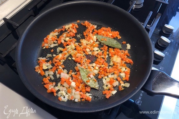 Разогрейте на сковороде растительное масло и обжарьте на нем нарезанный лук (примерно 2–3 минуты). Добавьте к луку морковь, чеснок и лавровый лист, перемешайте и обжаривайте еще 2 минуты.