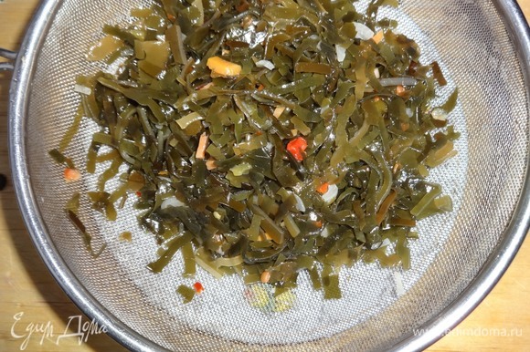 Салат из маринованной морской капусты откинуть на сито и дать стечь маринаду.