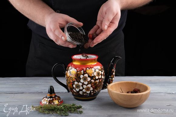 В керамическом чайнике от фабрики «Хохломская роспись» смешайте черный чай, чабрец и плоды шиповника.