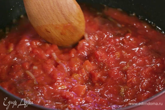 Не снимая сковороду с огня, добавить соевый соус, сахар и измельченные томаты в собственном соку, перемешать.