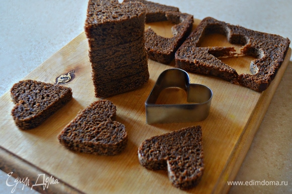 Из бородинского хлеба (1 маленькая буханка, 9 кусков, 18 сердечек) с помощью формочки для печенья вырежьте сердечки.