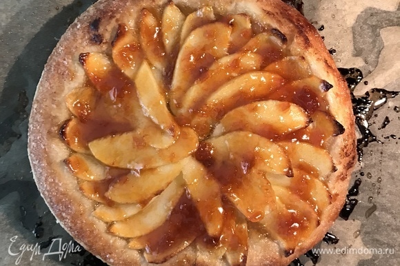 Когда тесто станет красивого золотистого цвета, осторожно смазать яблоки абрикосовым конфитюром, снова поставить пирог в духовку на 5 мин.