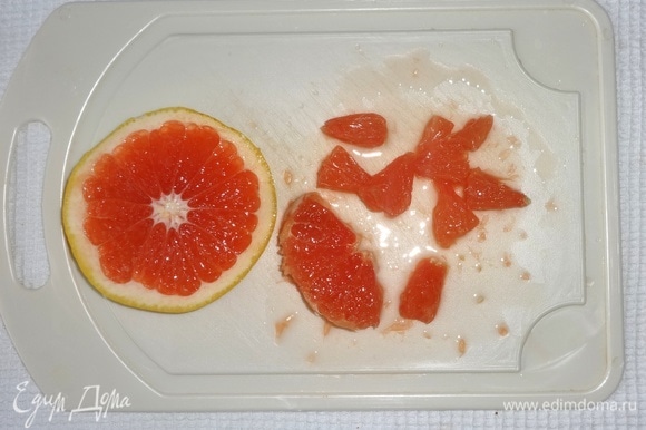 Оставшуюся часть грейпфрута разрезать на кружки. Очистить от кожуры и разобрать на дольки, освобождая от пленок.