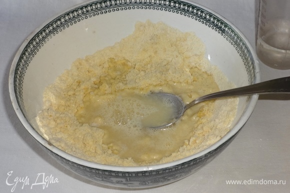 В масляно-мучную крошку влить порциями воду и замесить тесто.