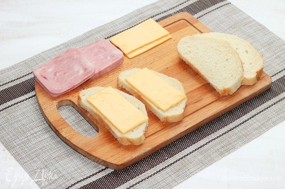 На 2 кусочка хлеба выложить по ломтику сыра.