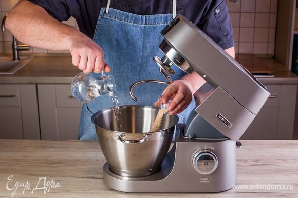 Разогрейте духовку до 250°С. В чашу кухонной машины KENWOOD влейте теплую воду, всыпьте дрожжи и дайте им раствориться.